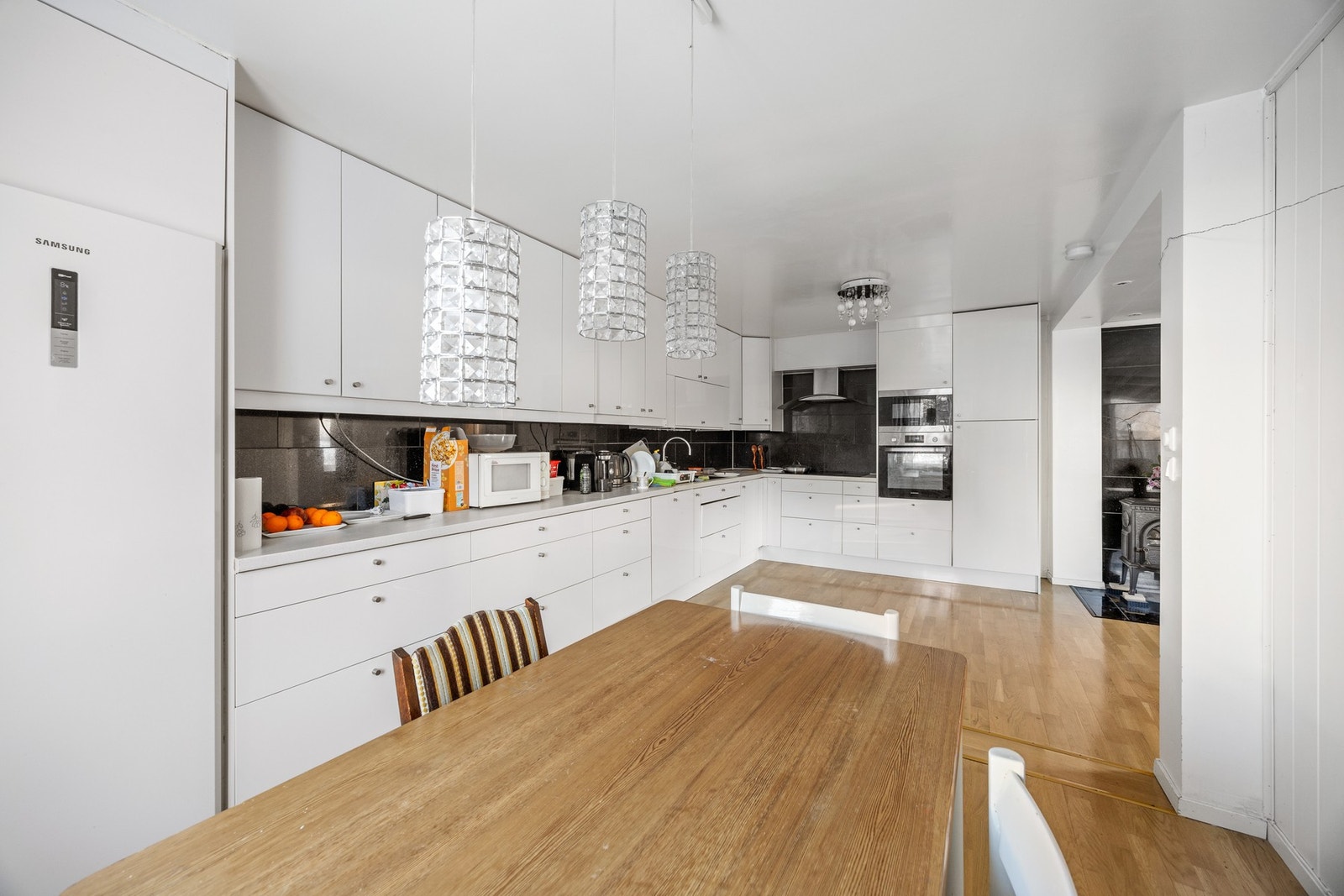 Pen kjøkkeninnredning med integrert stekeovn, platetopp og mikroovn, samt avsatt plass for kjøleskap. Galleribilde