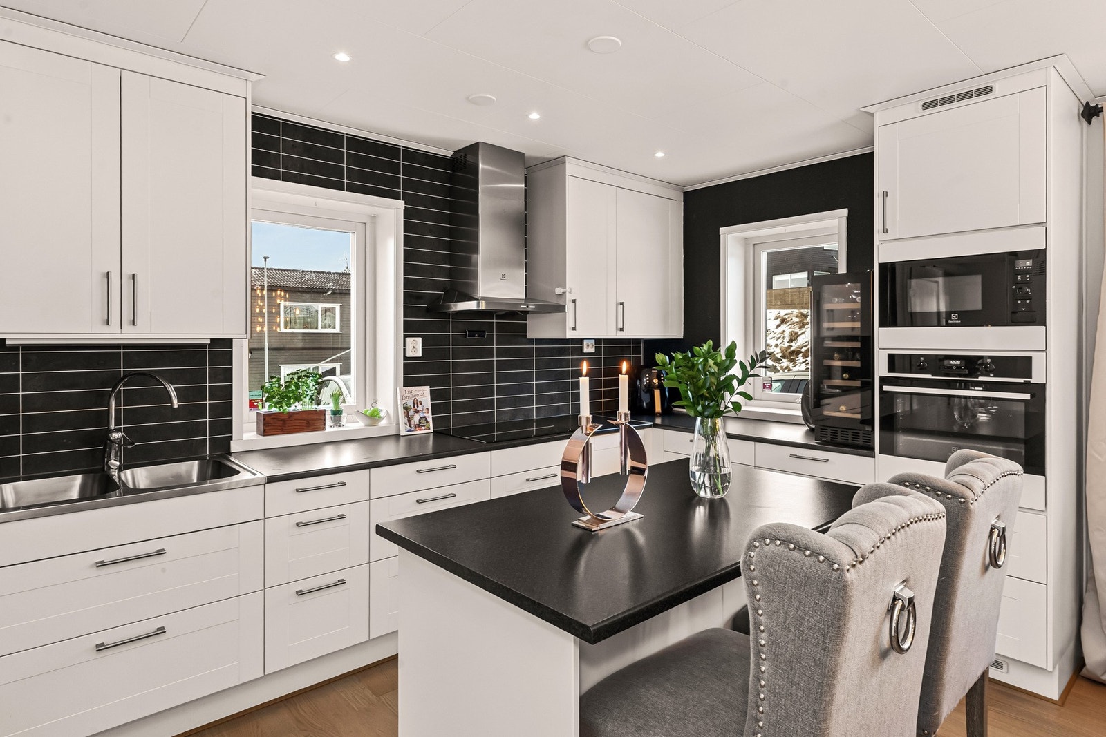 Kjøkkenet har profilerte fronter og laminert benkeplate, og leveres med integrerte hvitevarer (komfyr, platetopp, mikrobølgeovn og oppvaskmaskin), samt frittstående kjøleskap, fryser (ny i 2025) og vinskap Galleribilde