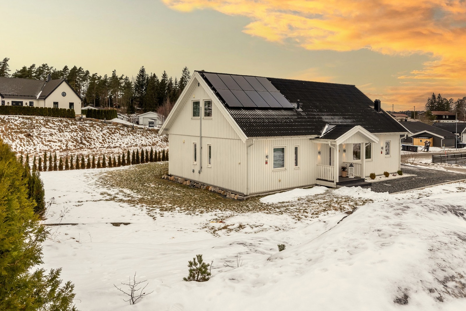 Tomten er stor og selveid med åpen hage, naturlig skjerming fra en markant fjellformasjon og solid granittmur som rammer inn eiendommen og gir et eksklusivt uttrykk helt frem til inngangen Galleribilde