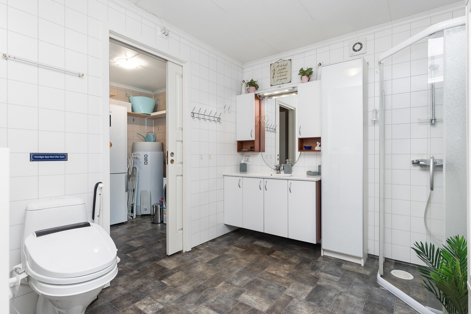 Romslig bad med praktisk skyvedør inn til vaskerommet Galleribilde