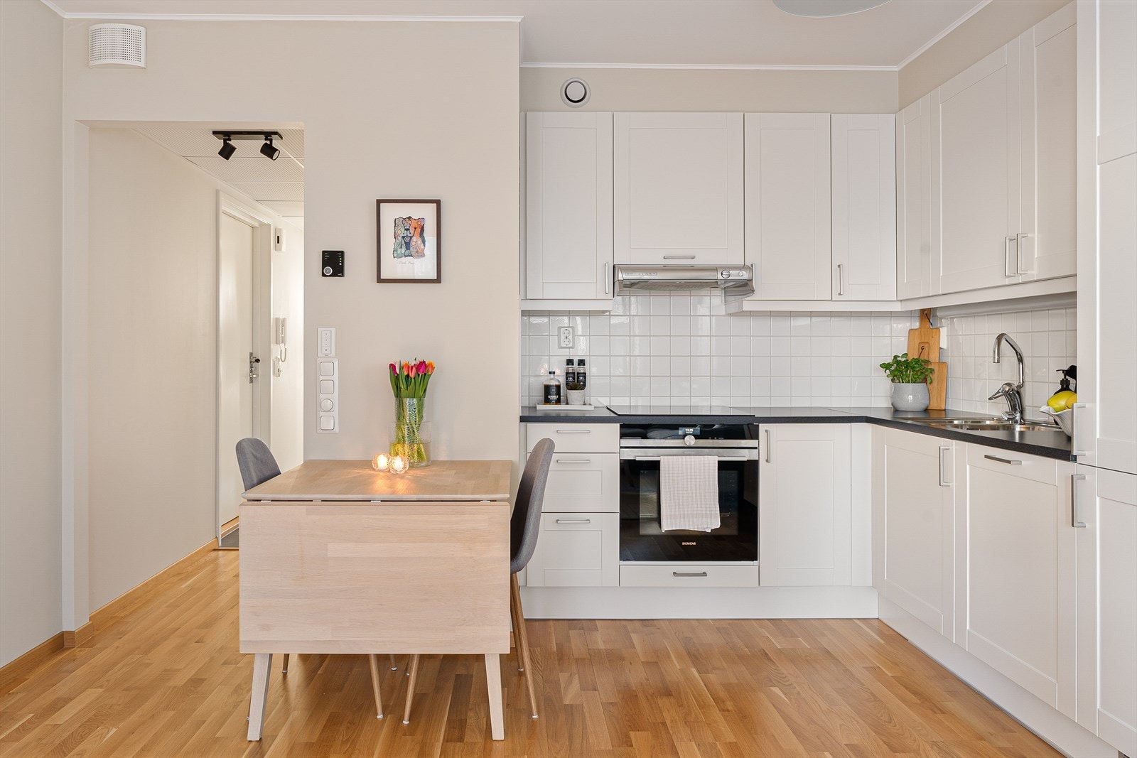 Kjøkkenet er i klassiske hvite fronter med svart benkeplate. Galleribilde