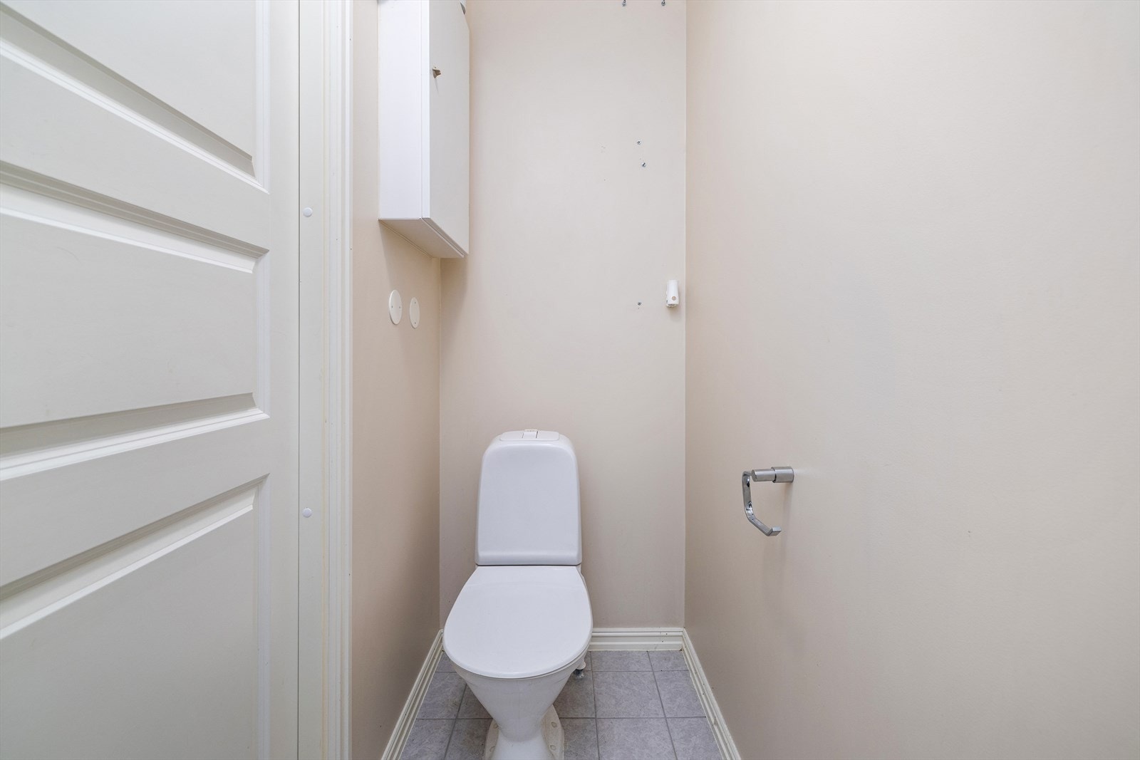 Praktisk toalettrom i første etasje med flislagt gulv, servant og toalett. Galleribilde