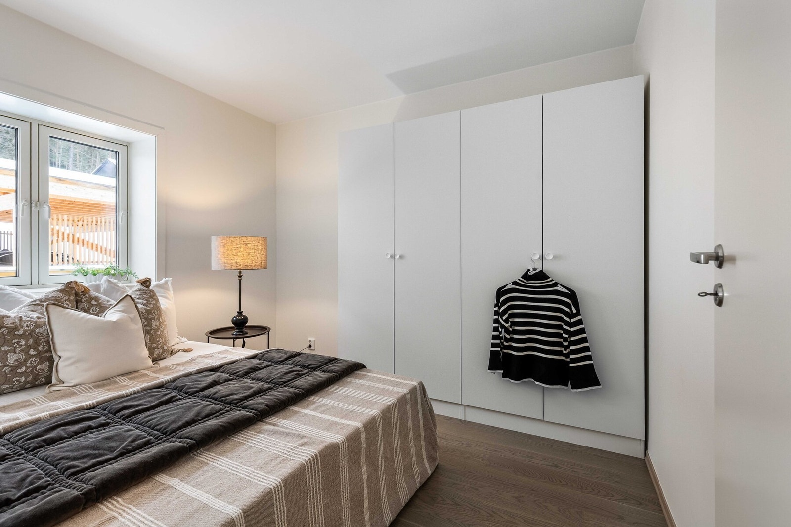 Soverommet er utstyrt med en romslig, integrert garderobeløsning med slette fronter i tråd med boligens moderne stil Galleribilde