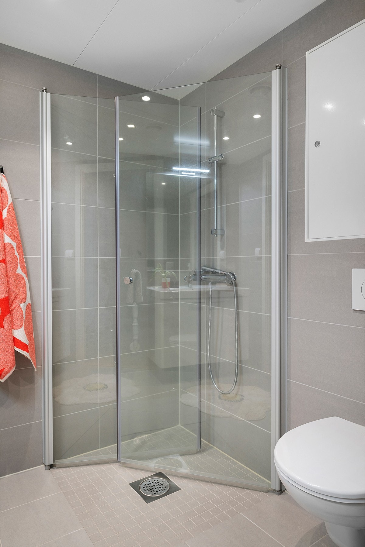 Badet består av inn- utadslående dusjvegger, servant m/underskap, speil m/overlys og veggklosett. Galleribilde