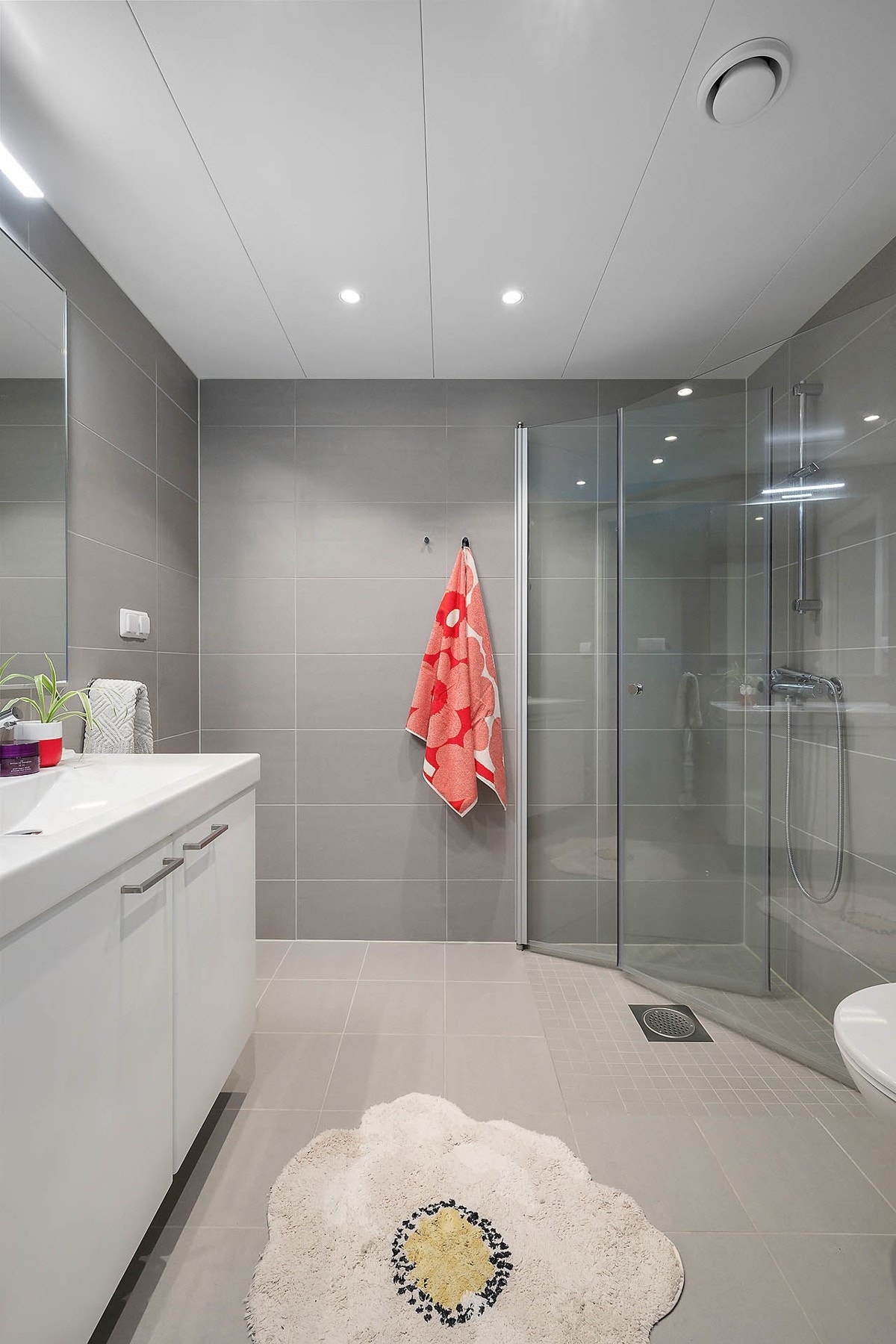 Leilighetens bad er moderne og delikat, med grå fliser i gulv og vegger, samt downlights i himling. Galleribilde