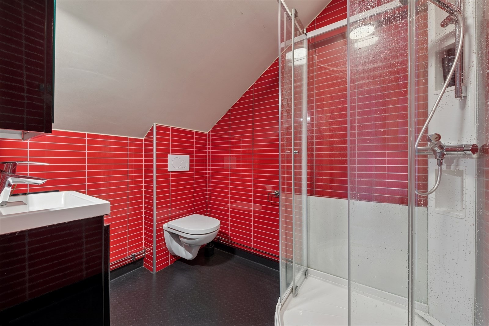 Bad/wc med bl.a. våtromsvinyl på gulv og baderomspanel på veggene. Rommet er utstyrt med dusjkabinett, vegghengt drenert klosett, servant samt baderomsinnredning med servantskap, speilskap og lys over speilskapet. Badet ble etablert i 2018. Galleribilde