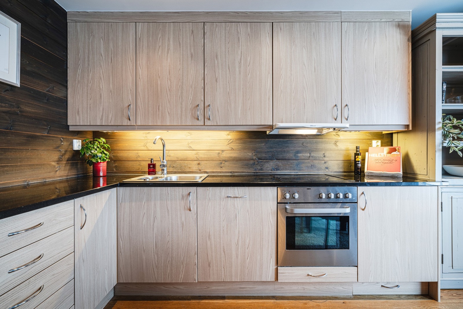 Stilrent kjøkken i lys treutførelse med åpen planløsning mot stue, som skaper en harmonisk og helhetlig romopplevelse. Galleribilde