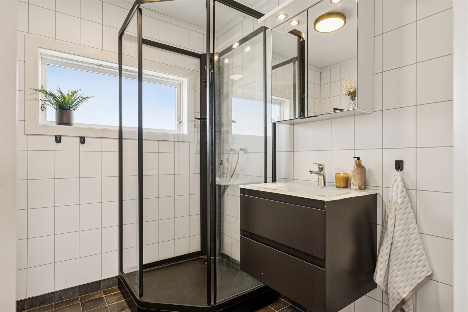 Innbydende bad i andre etasje innredet med dusjkabinett, toalett og baderomsseksjon, speil med oppbevaring og downlight belysning Galleribilde