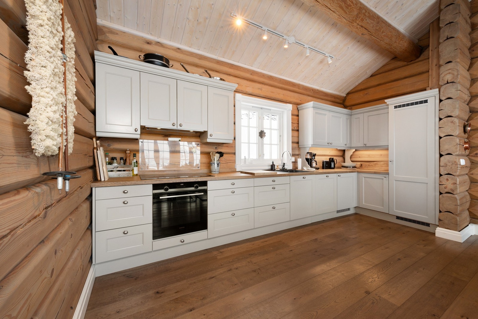 Stort kjøkken med lyse fronter. Kjøkkenet og alt annet som er plassbygd er laget av Uvdal snekkerverksted. Galleribilde