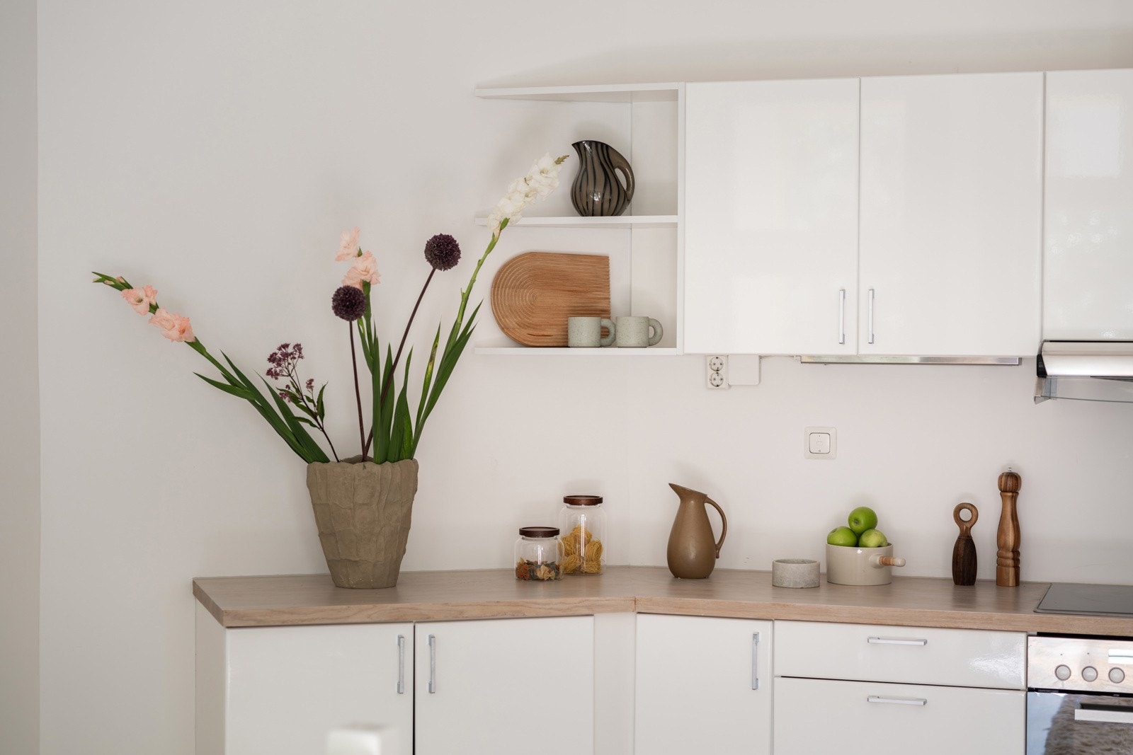 Innredningen har hvite glatte fronter og heltre benkeplate med nedfelt oppvaskkum. Praktisk med belysning under overskapene. Galleribilde