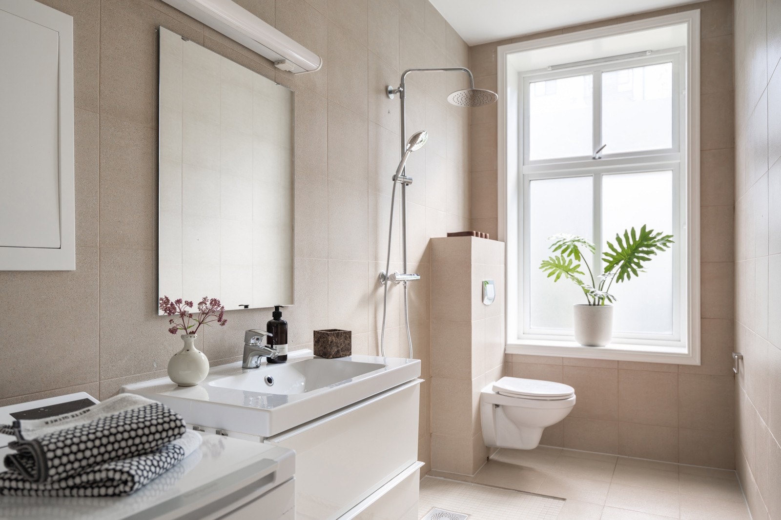 Baderom 1 er et lyst og pent flislagt baderom som ble pusset opp i 2012. Også baderommet har et stort klassisk vindu som slipper inn deilig dagslys, samt god takhøyde. Galleribilde