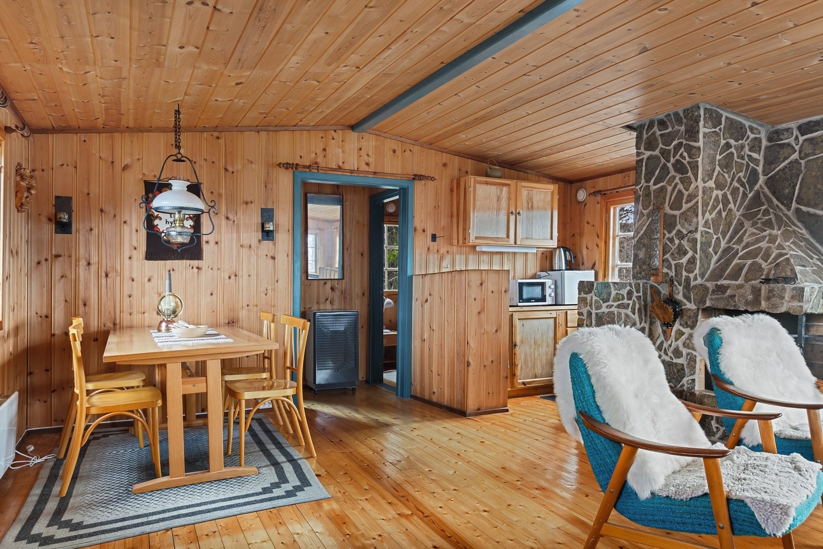 Flere vinduer som slipper inn godt med lys og en stor, plassmurt peis gir en hyggelig stemning til rommet. Galleribilde