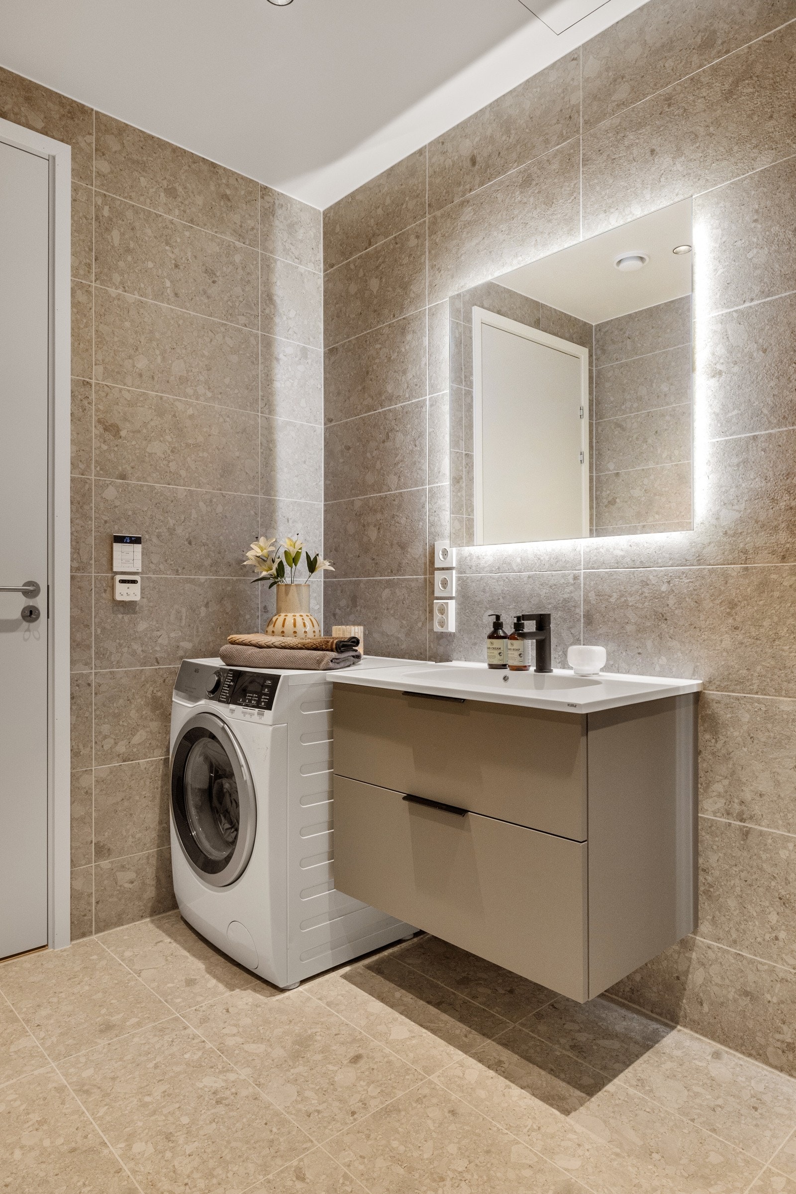 Videre er det plass og opplegg for vaskemaskin, så her har du alt du trenger på baderommet! Galleribilde