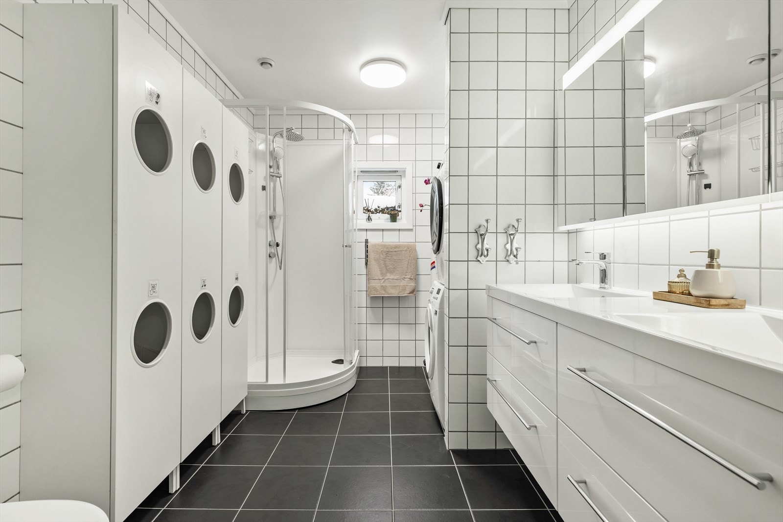 Badet er innredet med nedfelt dobbel servant, vegghengt toalett, speilskap og dusjkabinett. Galleribilde