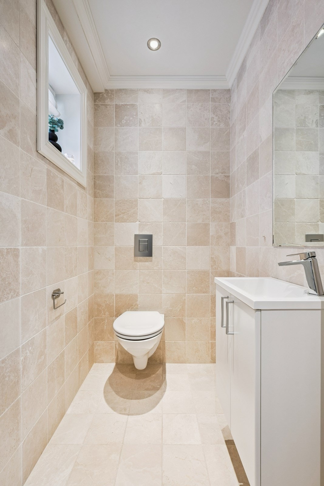 Funksjonelt toalettrom i første etasje med fliser på gulv og vegger Galleribilde