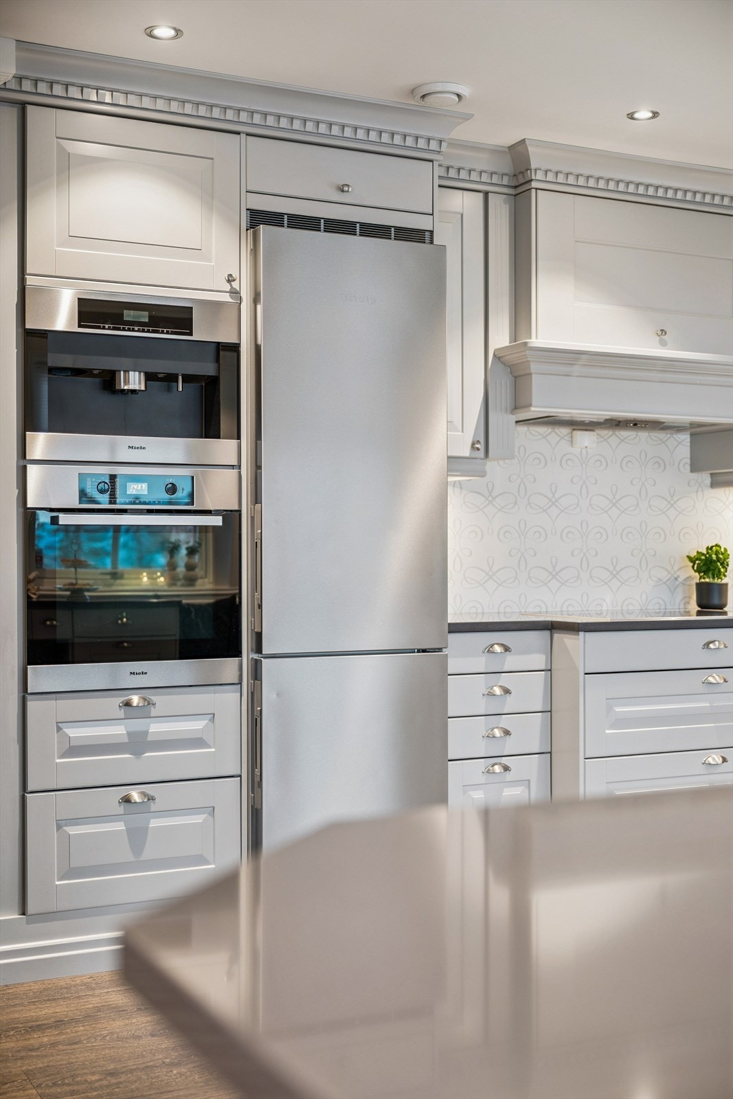 Kjøkkenet er utstyrt med integrerte hvitevarer fra Miele, inkludert kaffemaskin og stekeovn Galleribilde