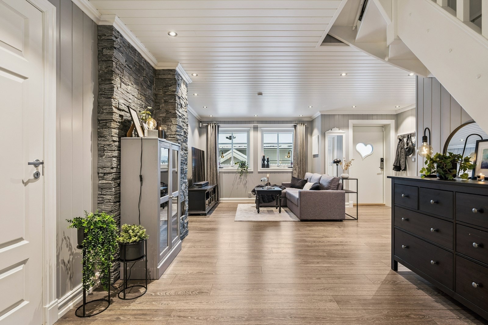 Den romslige stuen i underetasjen har gulvvarme for ekstra komfort. Stuen har egen utgang til steinlagt uteplass og hagen Galleribilde