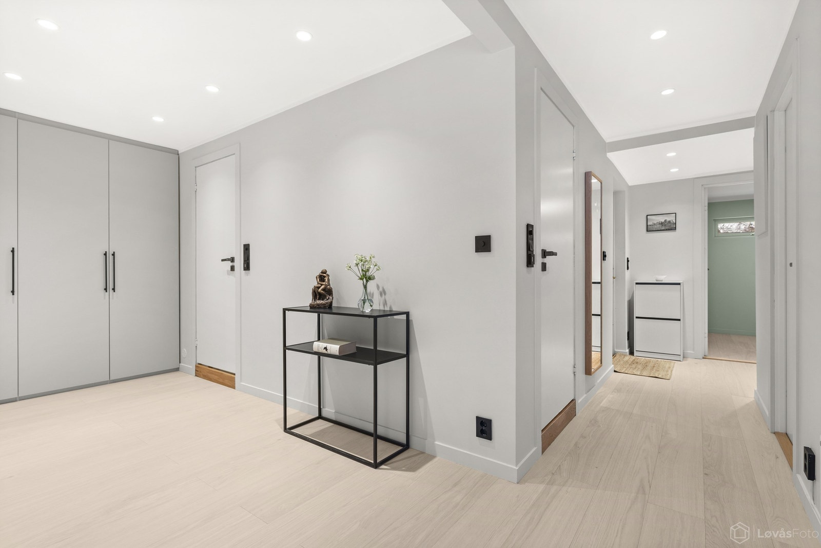 Romslig gang med 1-stavs parkett og downlights i himling. Plassbygde garderobeskap. Fra gangen er det utgang til vestvendt og overbygget terrasseplatting med adkomst videre til liten hage Galleribilde