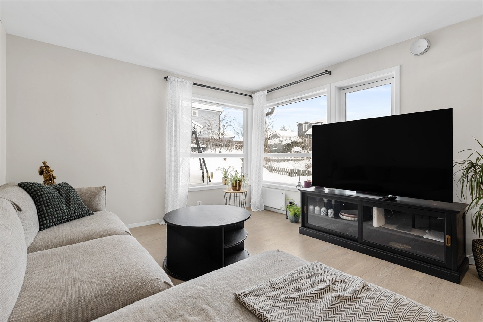 Store vindusflater gir rikelig med naturlig lys inn i stuen. Galleribilde