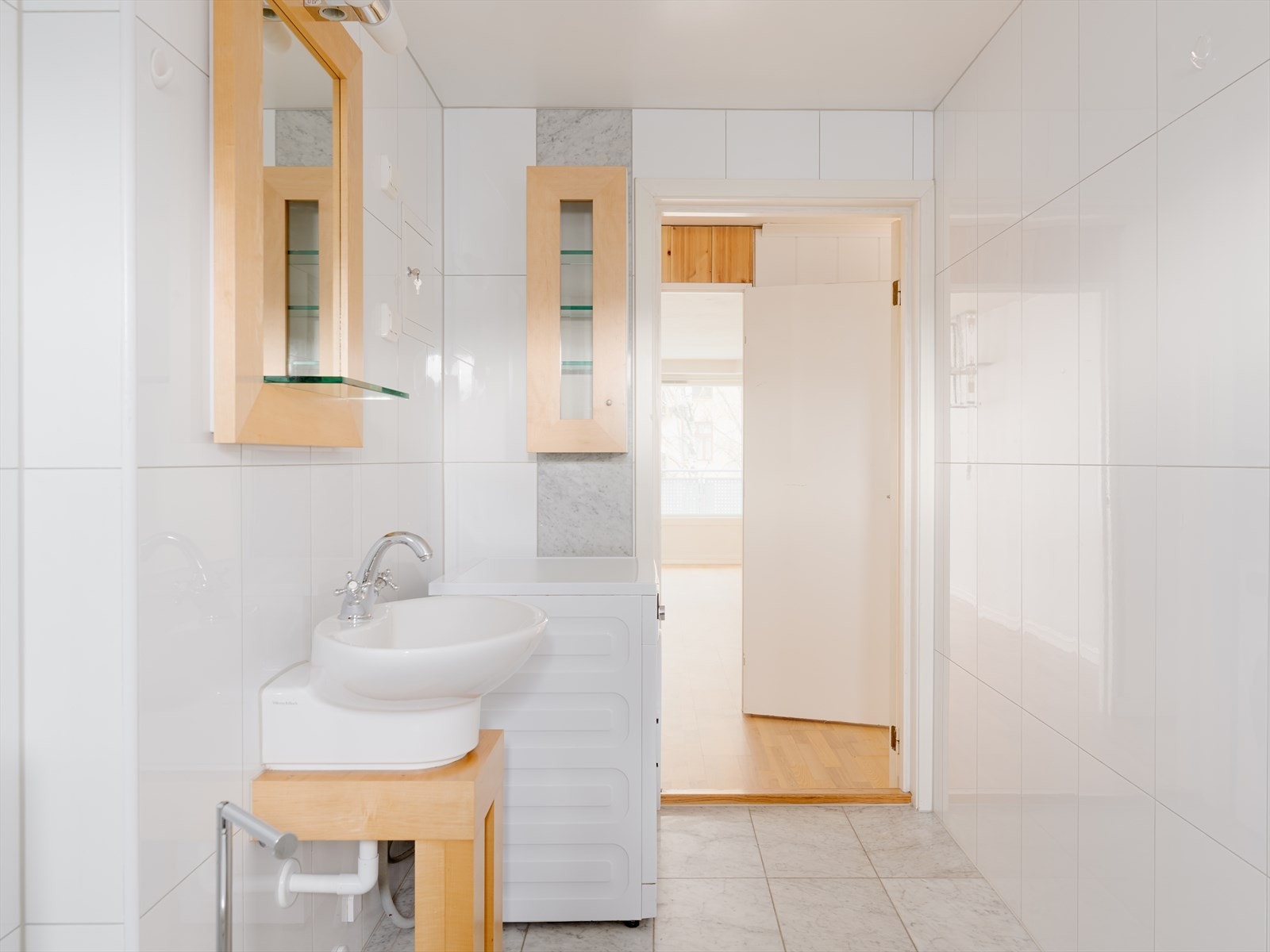 Badet består av dusj på gulv med fast felt i herdet glass, badekar, servant, klosett og opplegg for vaskemaskin. Galleribilde