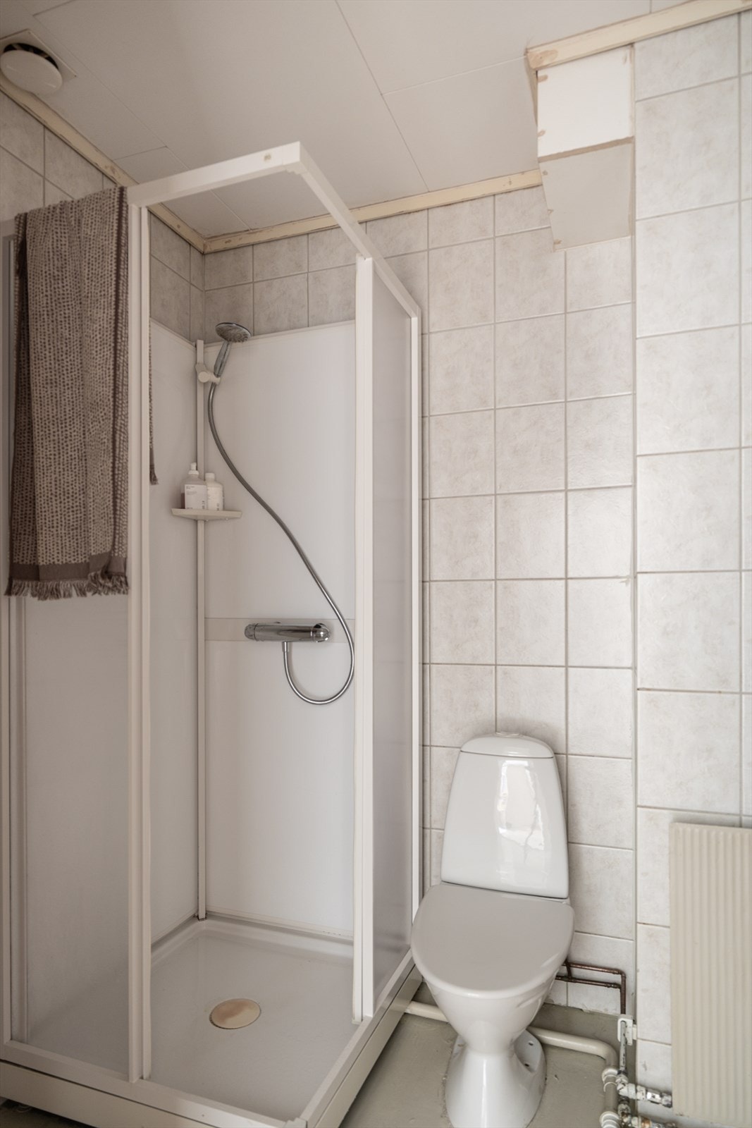 Badet har behov for modernisering og er utstyrt med toalett, vask og dusjkabinett. Galleribilde