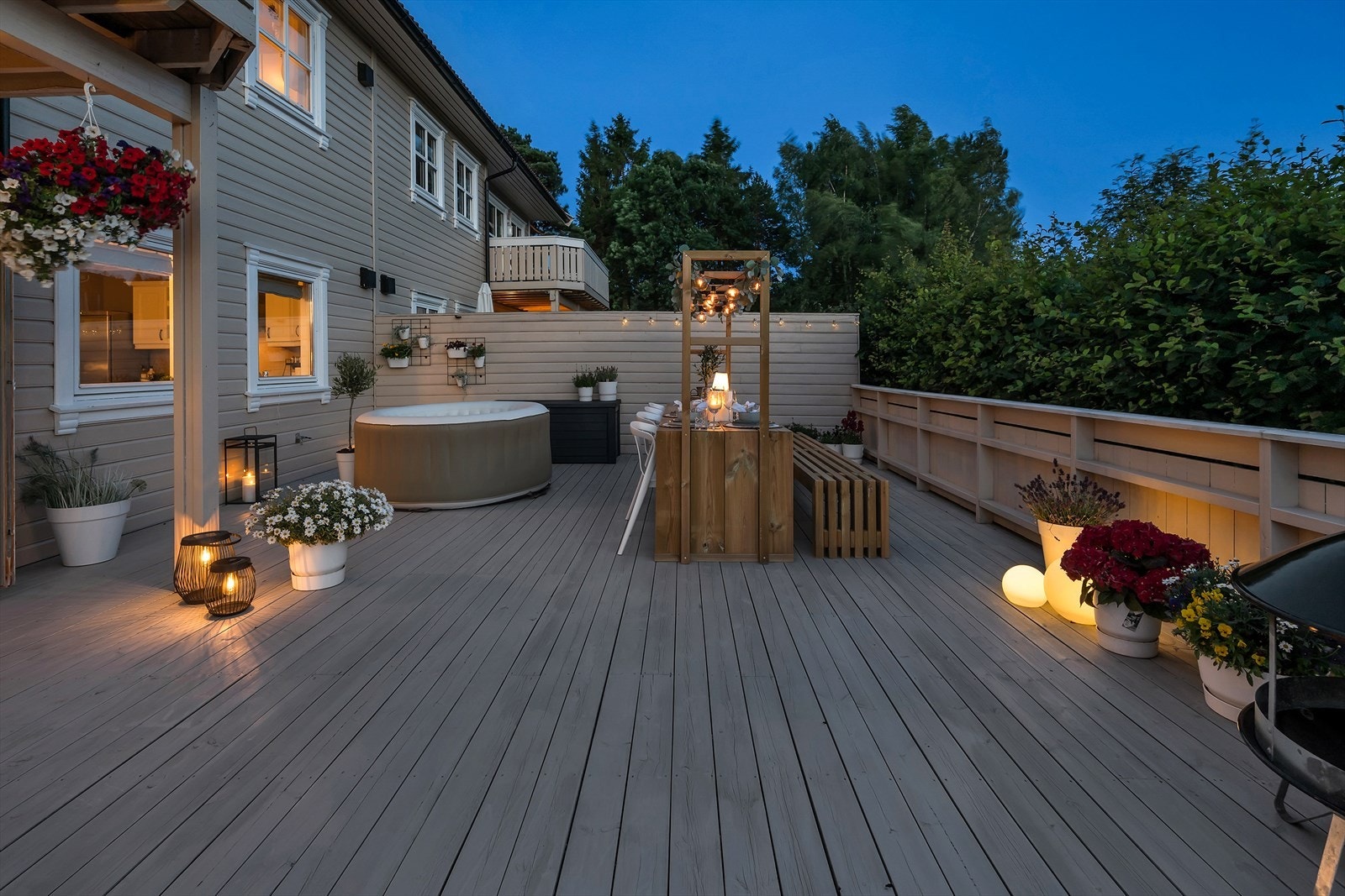 Terrassen er omkranset av rekkverk og en hekk, noe som bidrar til privatliv og skaper en skjermet og usjenert uteplass. Galleribilde