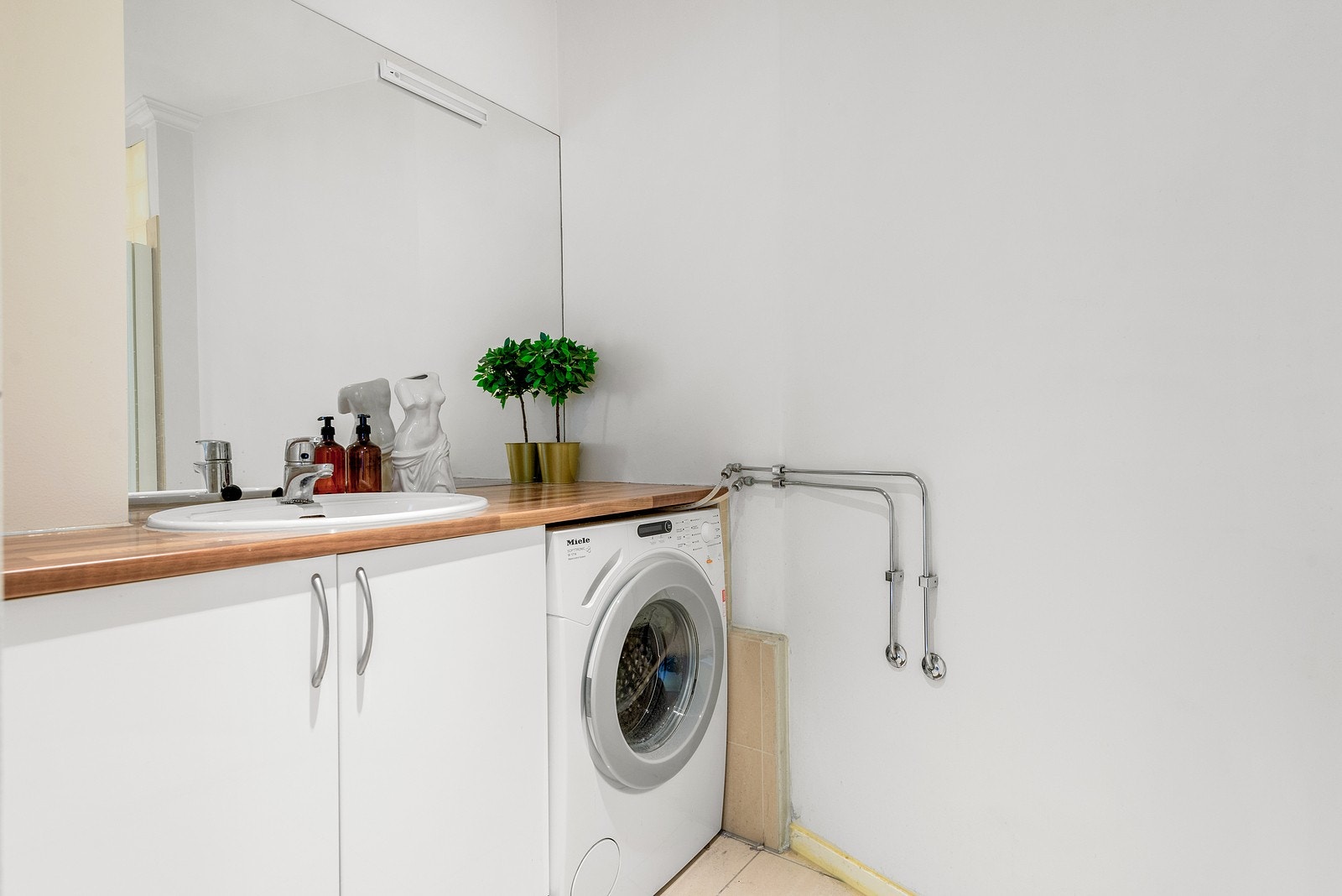 Praktisk vaskerom kombinert med bad, med opplegg for vaskemaskin og varme i gulvet. Galleribilde