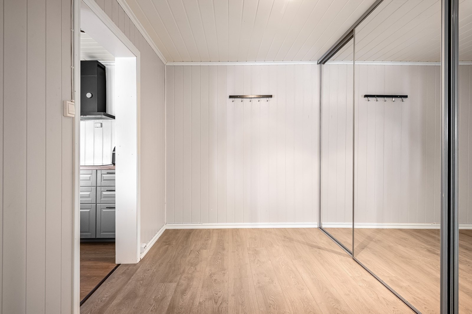 Et praktisk omkledningsrom med skyvedørsgarderobe med speilfronter. Galleribilde