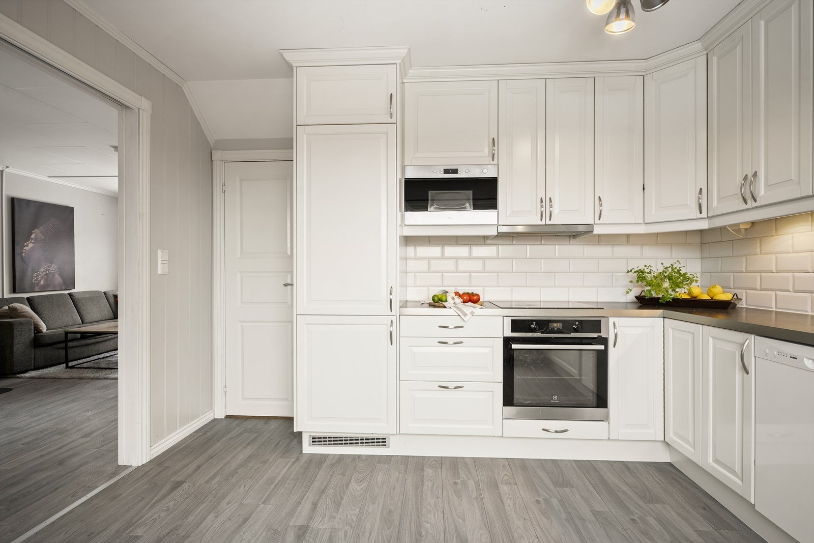 Kjøkkenet har Epoq-innredning fra 2014 med hvite, profilerte fronter og laminat benkeplate med planlimt kum i rustfritt stål Galleribilde