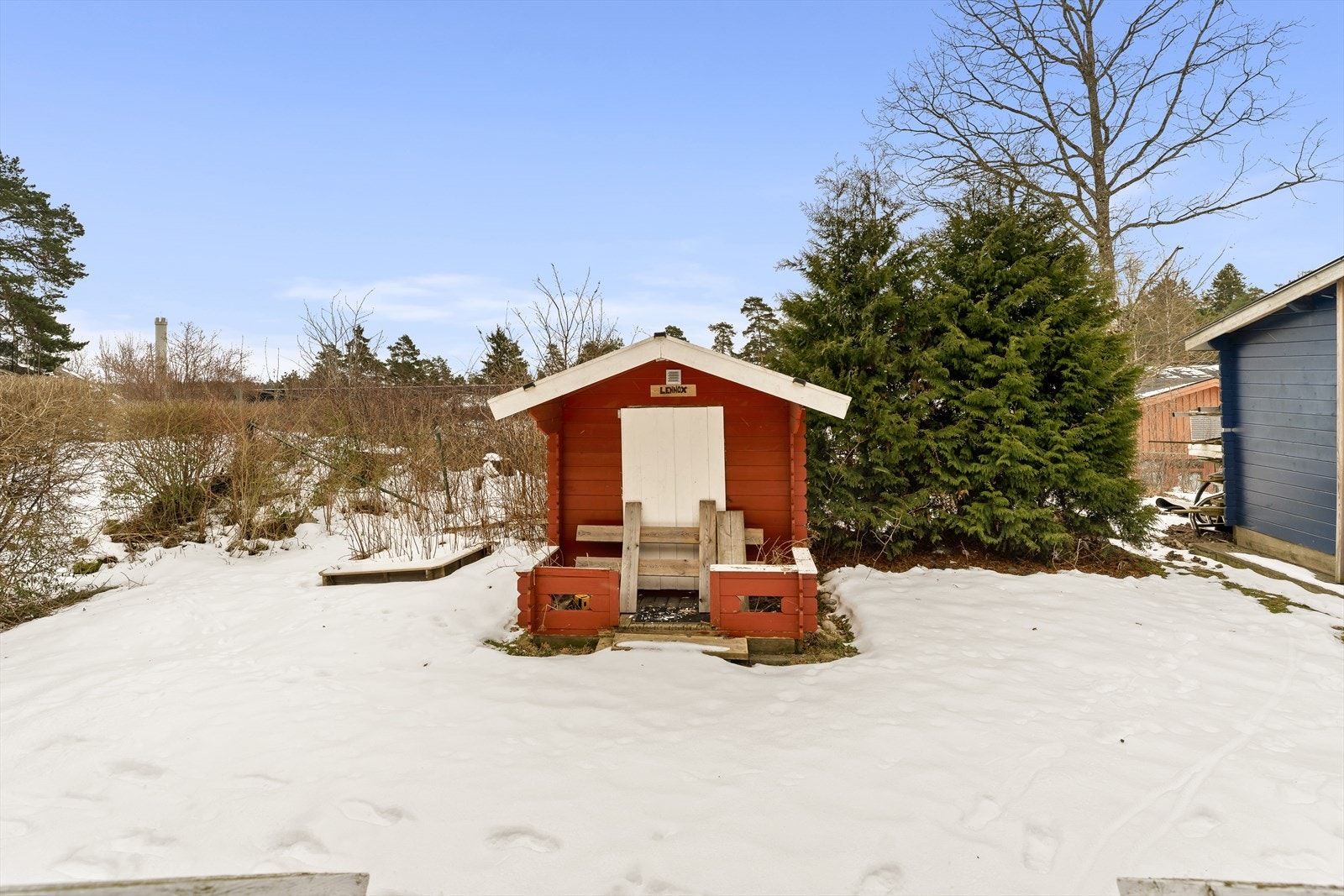 Større opparbeidet gressplen med diverse beplantning og lekehus Galleribilde