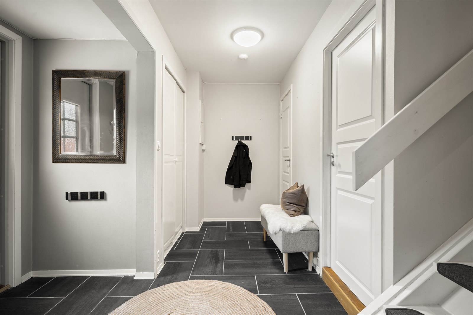 Romslig entré med flislagt gulv og egen garderobe Galleribilde