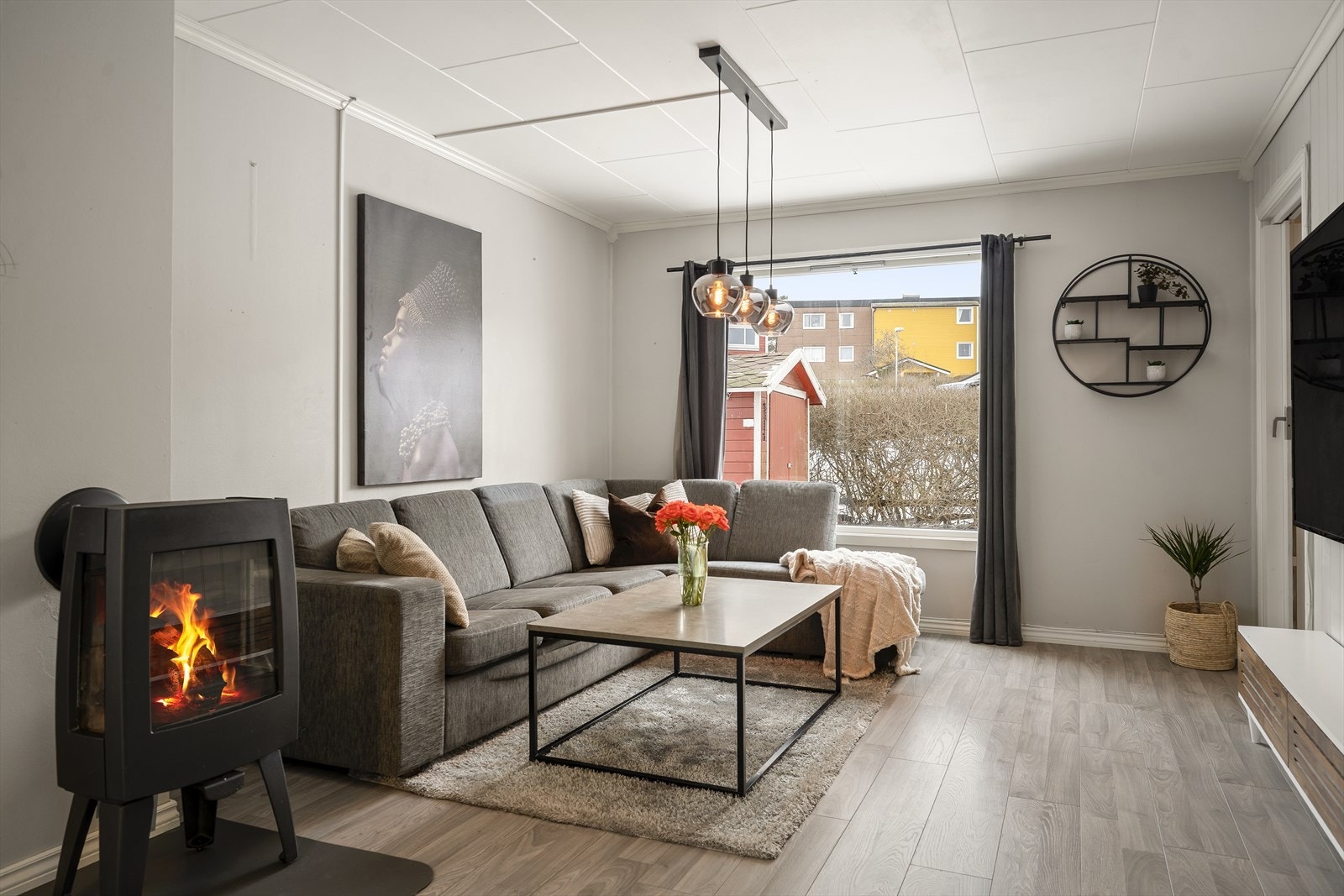 Stuen har stor vindusflate som slipper inn rikelig med naturlig lys og vedovn Galleribilde