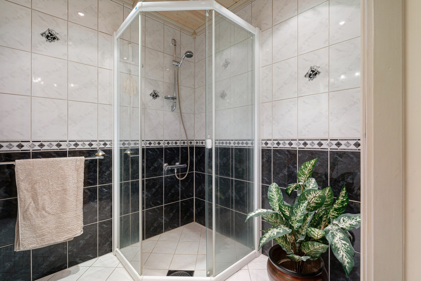 Dusjhjørne, lys baderomsinnredning og downlights i tak. Galleribilde