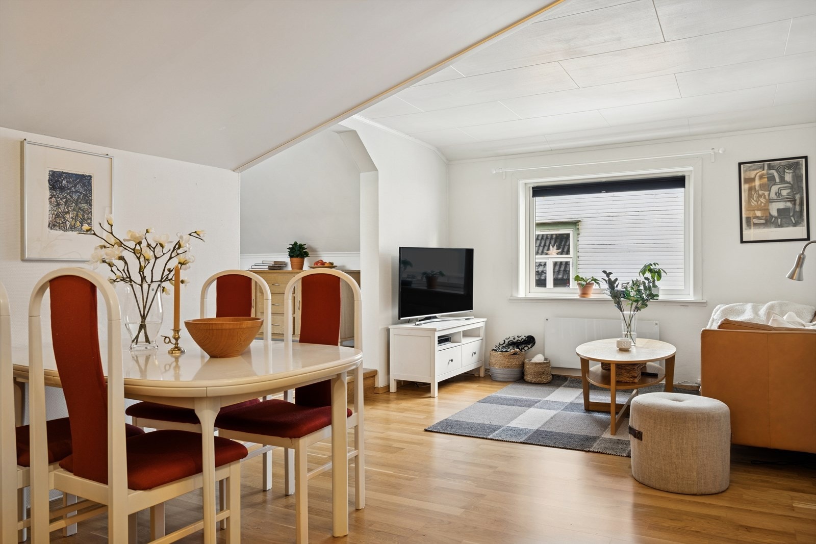 Stuen har parkettgulv og lysmalte vegger og noe skråtak. Galleribilde