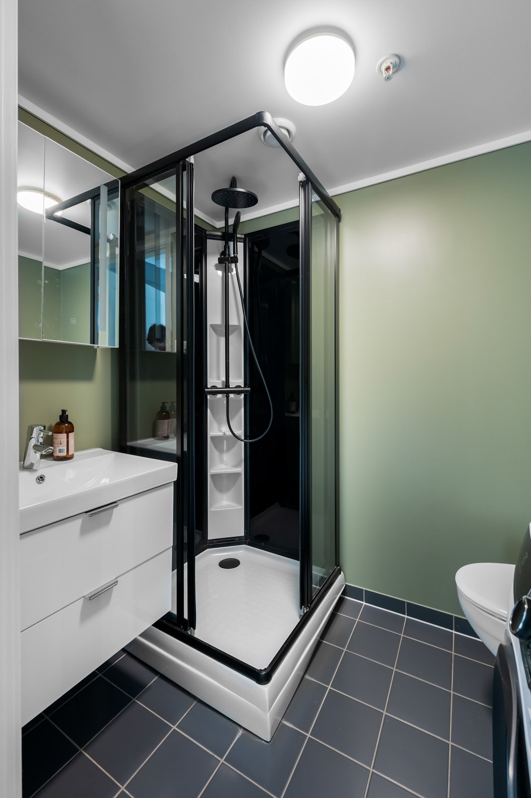 Badet i 1. etasje har nyere innredning i form av skuffeservant, speilskap og dusjkabinett Galleribilde