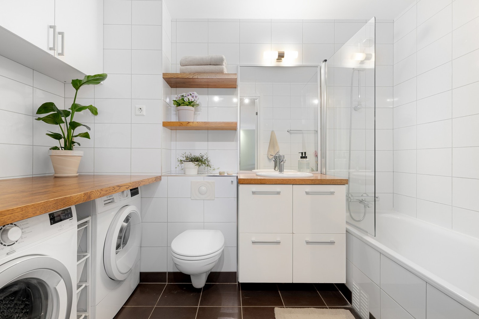 Tidløst baderom fra 2005. Benkeplaten fungerer som praktisk arbeidsbenk/stellebord, med plass til vaskemaskin og tørketrommel under. Galleribilde