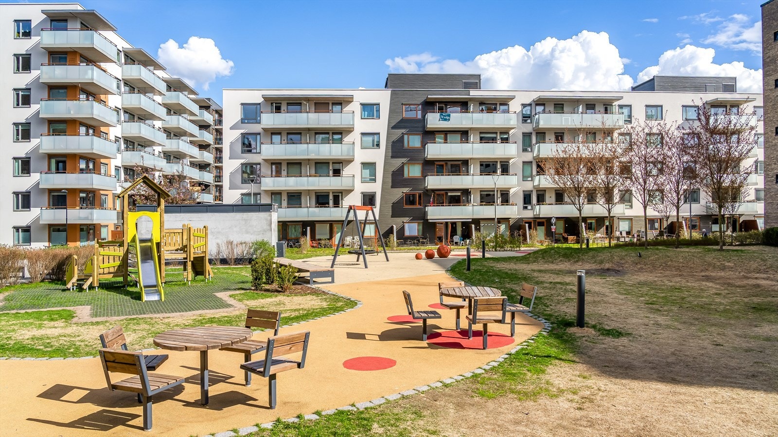 Felles og pent opparbeidet felles gårdsrom sett fra sommerstid. Galleribilde