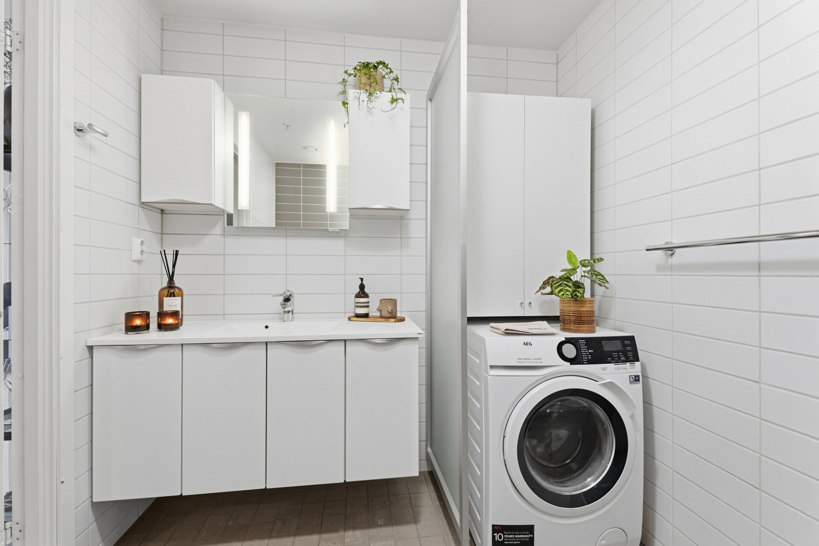 Badet er innredet med, klosett, servant over servantskap med glatt utførelse og dusjhjørne. Galleribilde