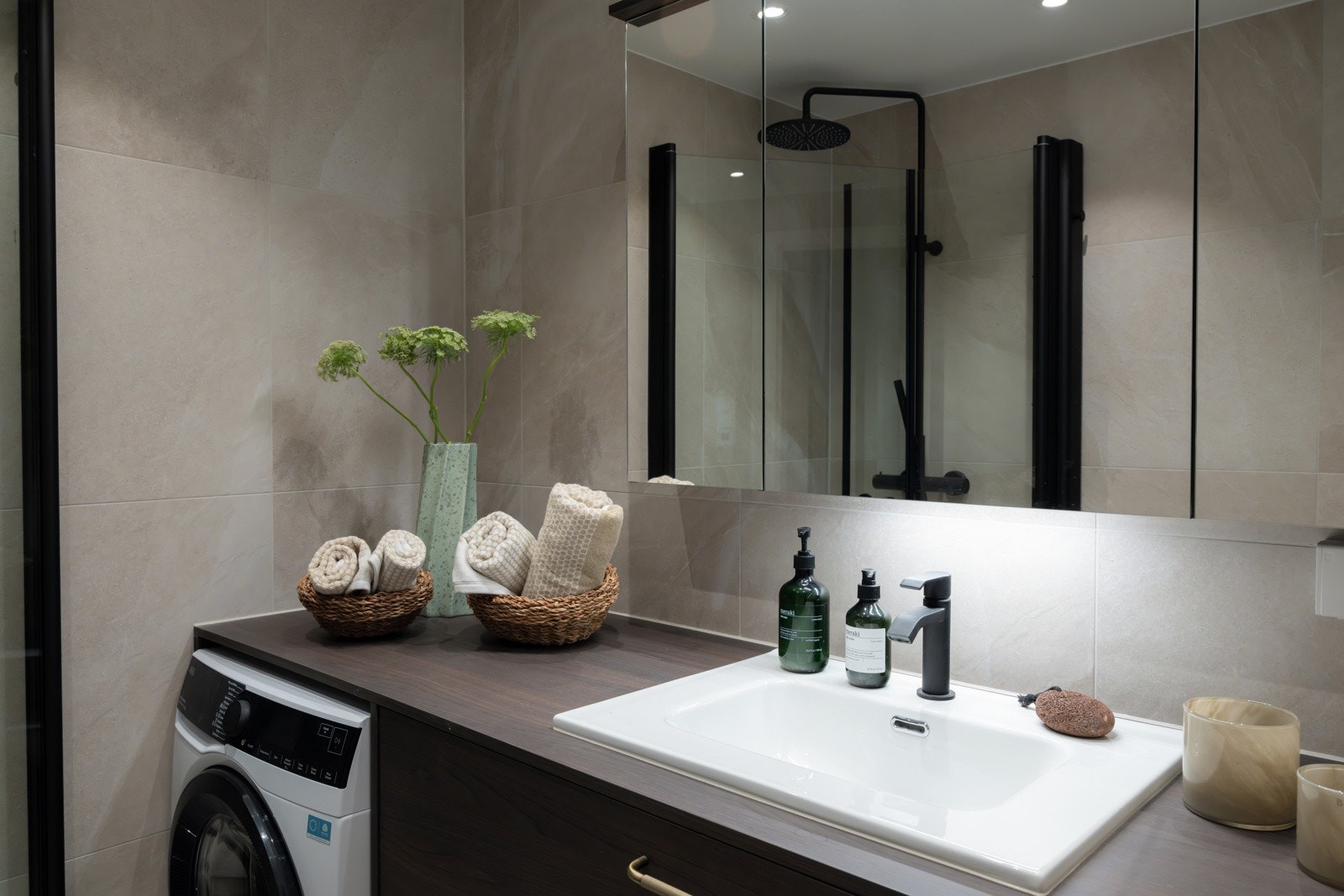 Badet er utstyrt med vegghengt servantinnredning med skuffer, laminat benkeplate med nedfelt servant, samt speilskap med overlys og stikkontakter over servant. Galleribilde