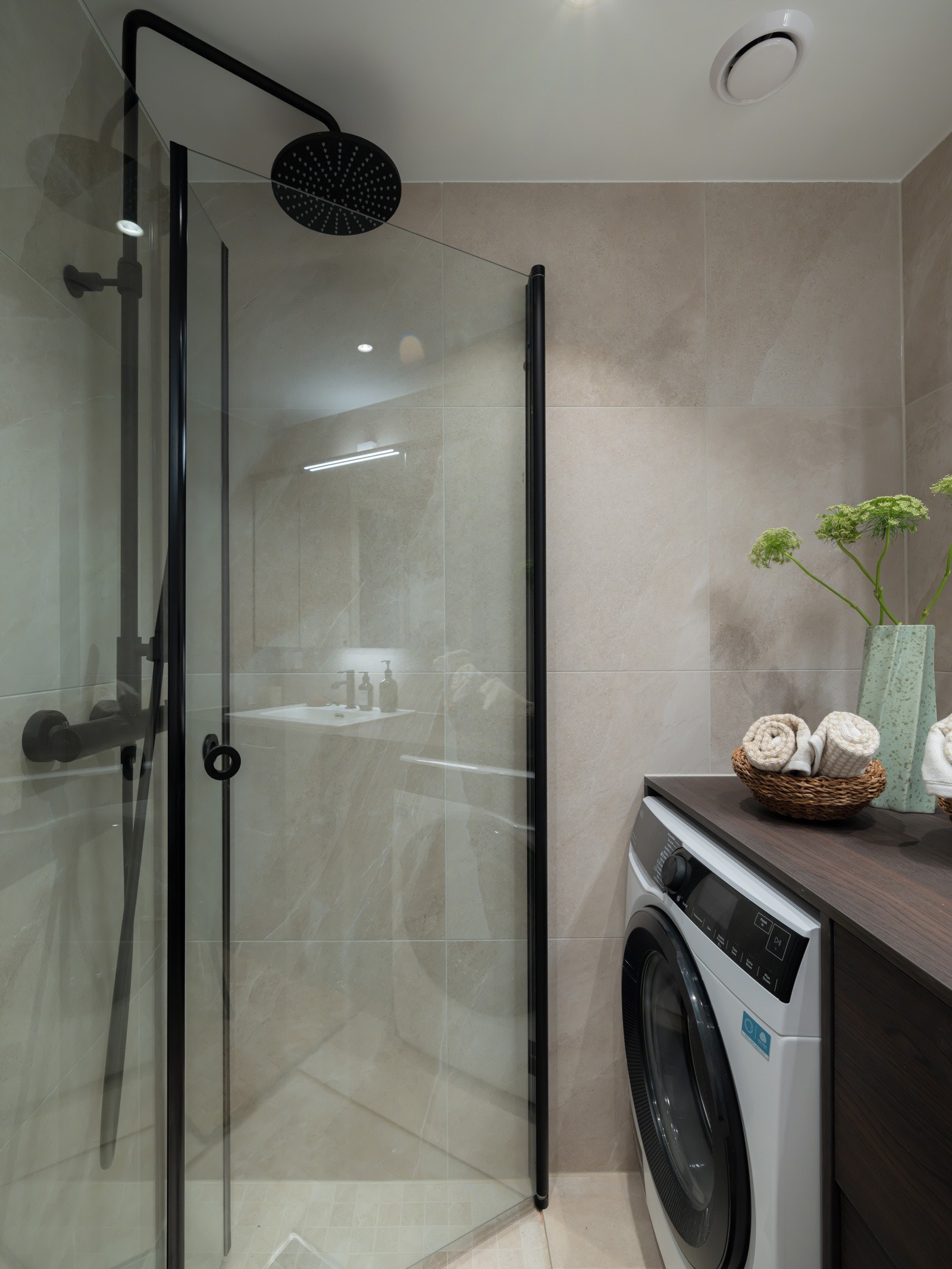 Videre har badet dusjhjørne med glassdører, hånddusj og regndusj, samt opplegg for vaskemaskin. Galleribilde