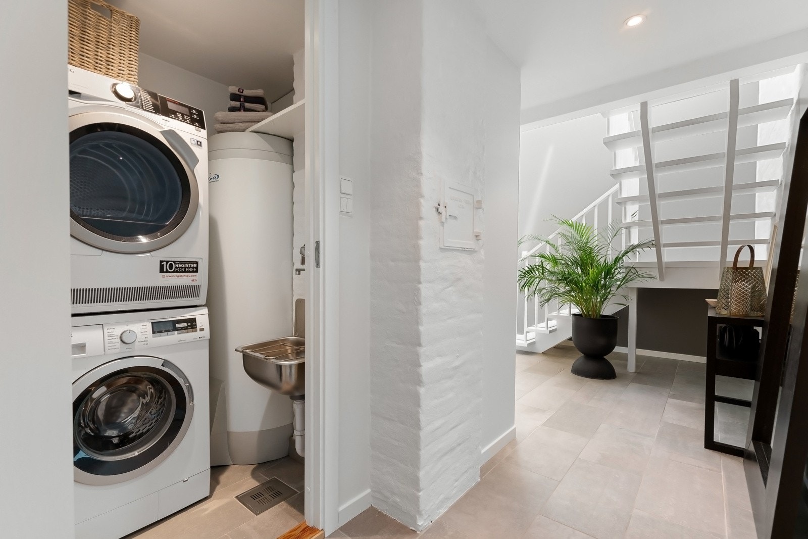 Praktisk vaskerom med opplegg for vaskesøyle og utslagsvask. Galleribilde