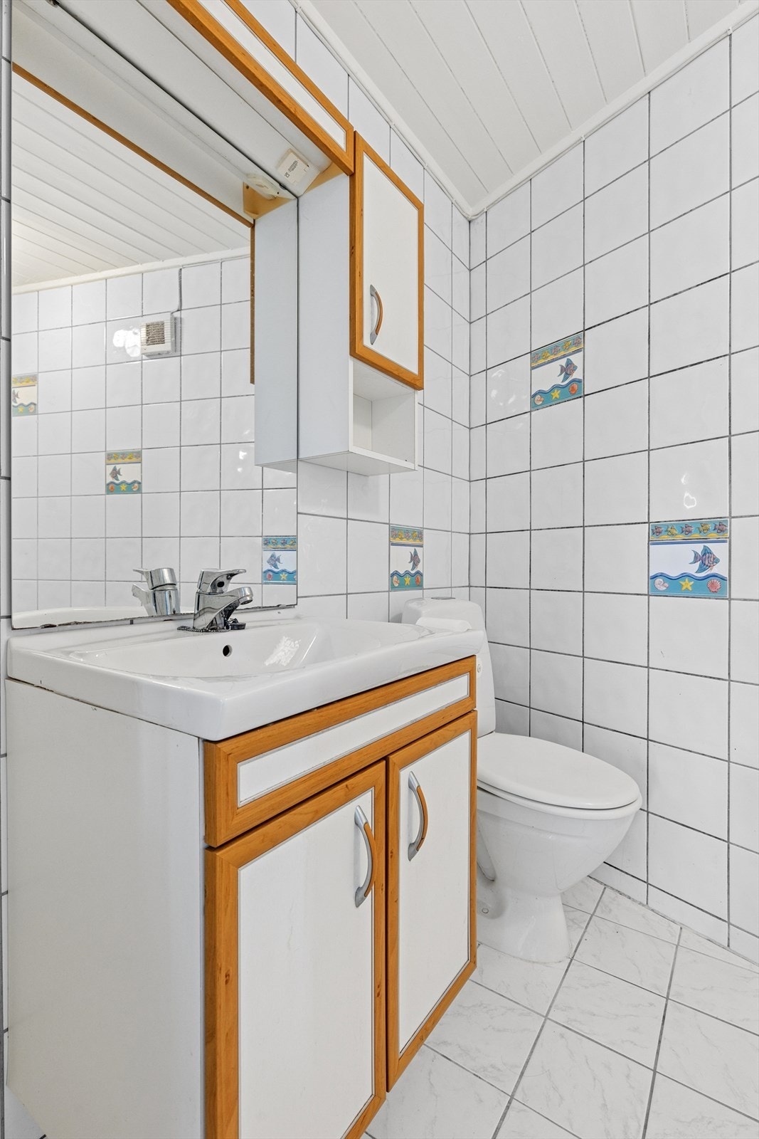 Flislagt bad med dusj, wc og servantinnredning. Galleribilde