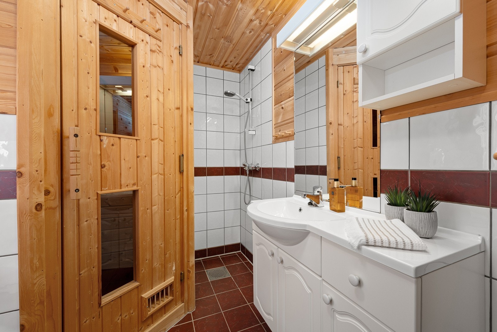 Hovedbadet med dusjhjørne, wc, servant med innredning og badstue Galleribilde