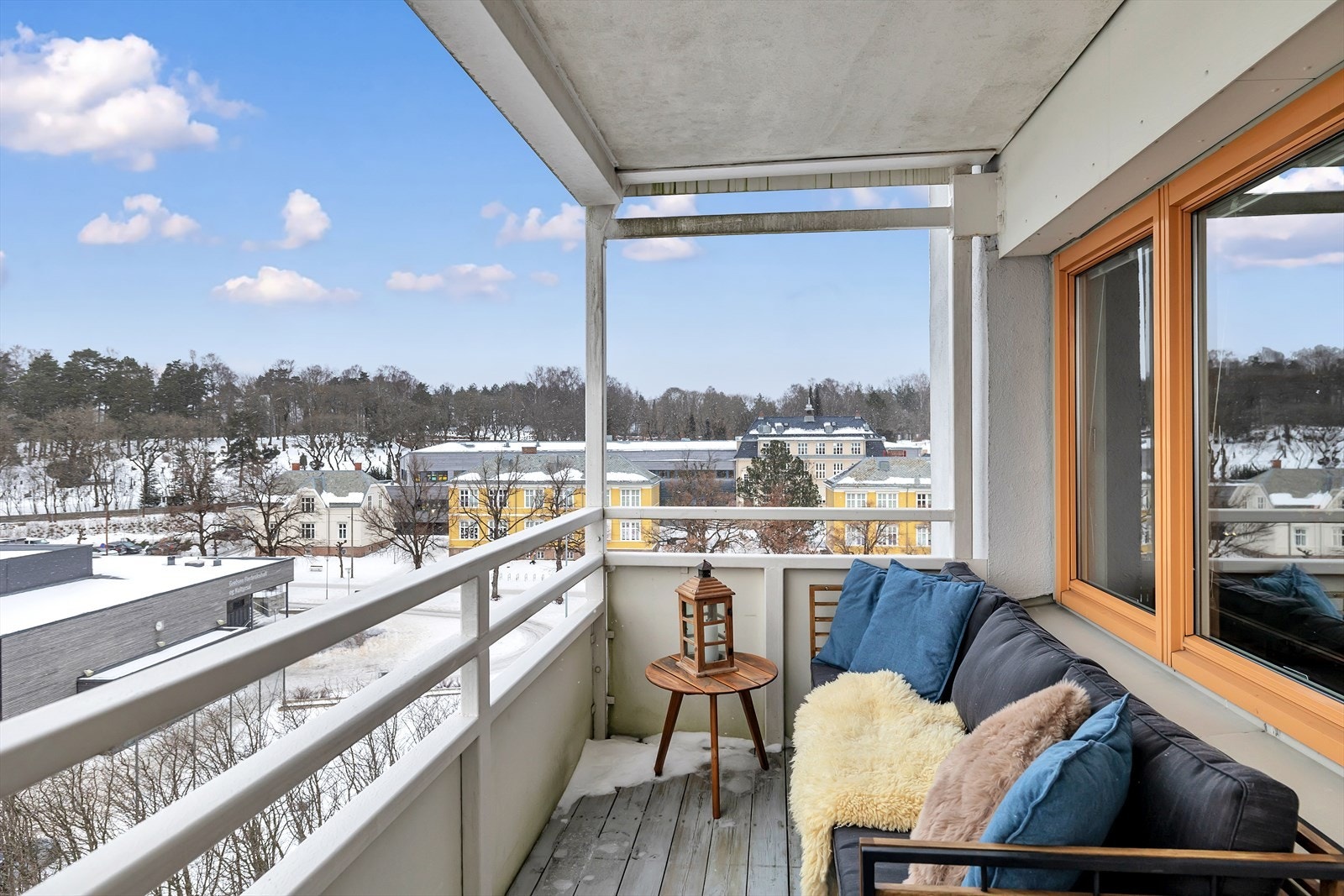 Rekkverket på balkongen er utformet med malte plater og håndløper i stål, med utsikt mot nærliggende bygninger. Galleribilde