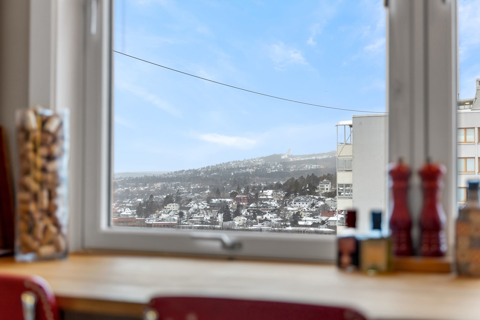 Utsyn mot omkringliggende landskap gir en følelse av åpenhet fra kjøkkenets spiseplass. Galleribilde