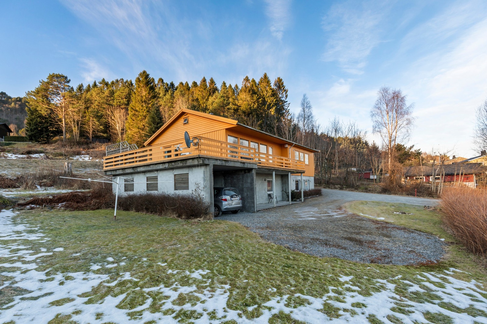 På fremsiden av boligen er det opparbeidet gruset biloppstillingsplass. Integrert garasje under terrasse. Galleribilde