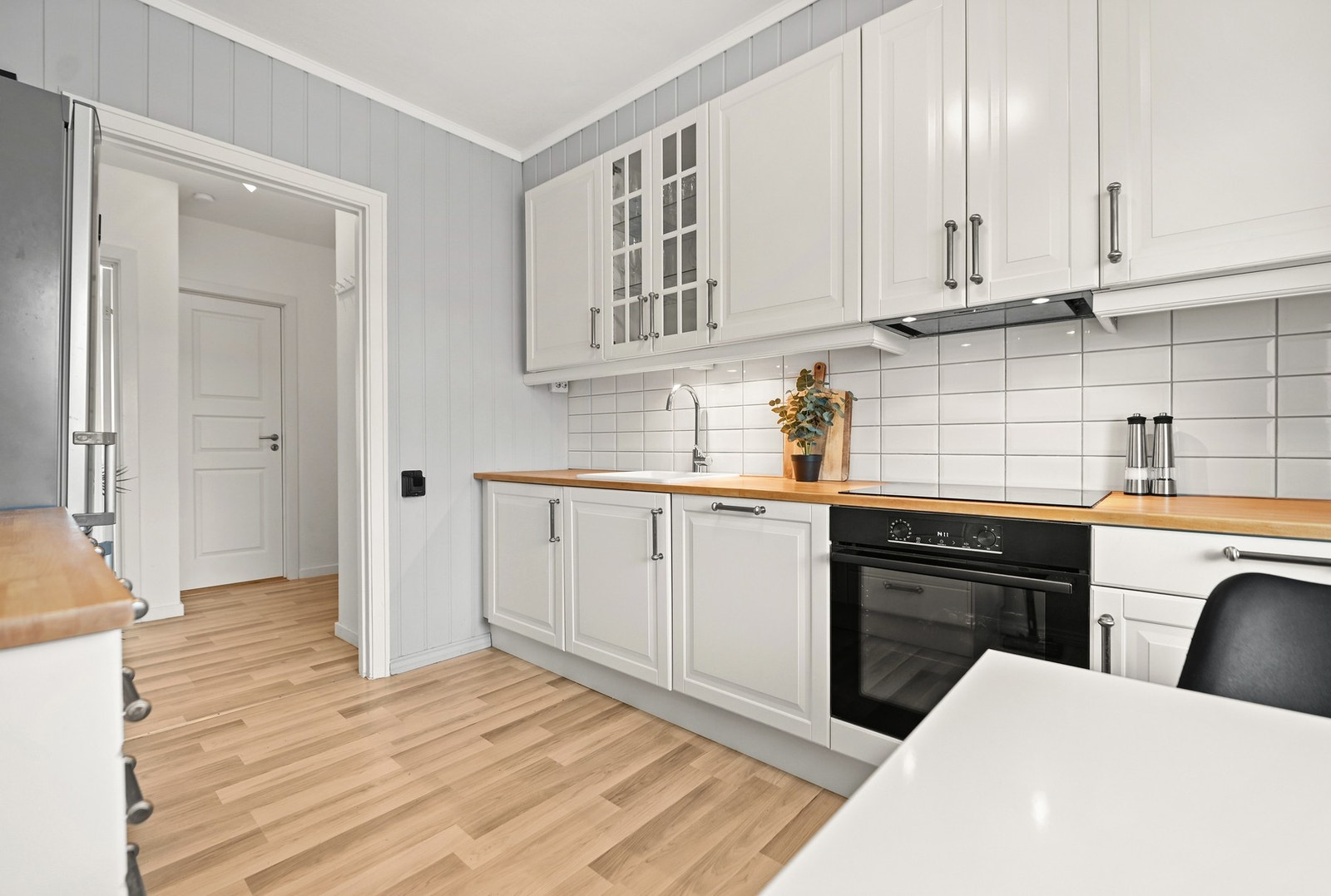 Kjøkkenet er innredet med profilerte fronter fra Ikea og heltre benkeplate. Det er porselensvask og fliser mellom over og underskap.
Integrerte hvitevarer som komfyr, platetopp og oppvaskmaskin.
Ny komfyr i 2024. Ny vask og blandebatteri i 2025. Benken b Galleribilde