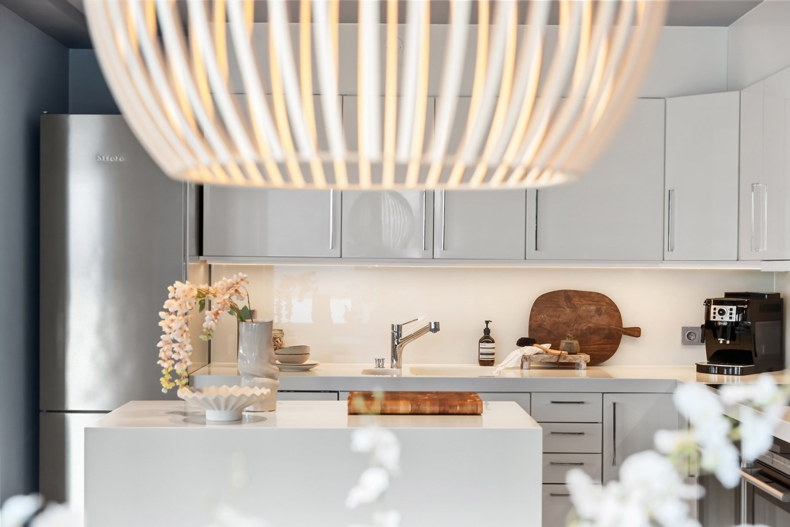 Stilig påkostet benkeplate av Corian som også dekker hele frontsiden av kjøkkenøyen. Galleribilde