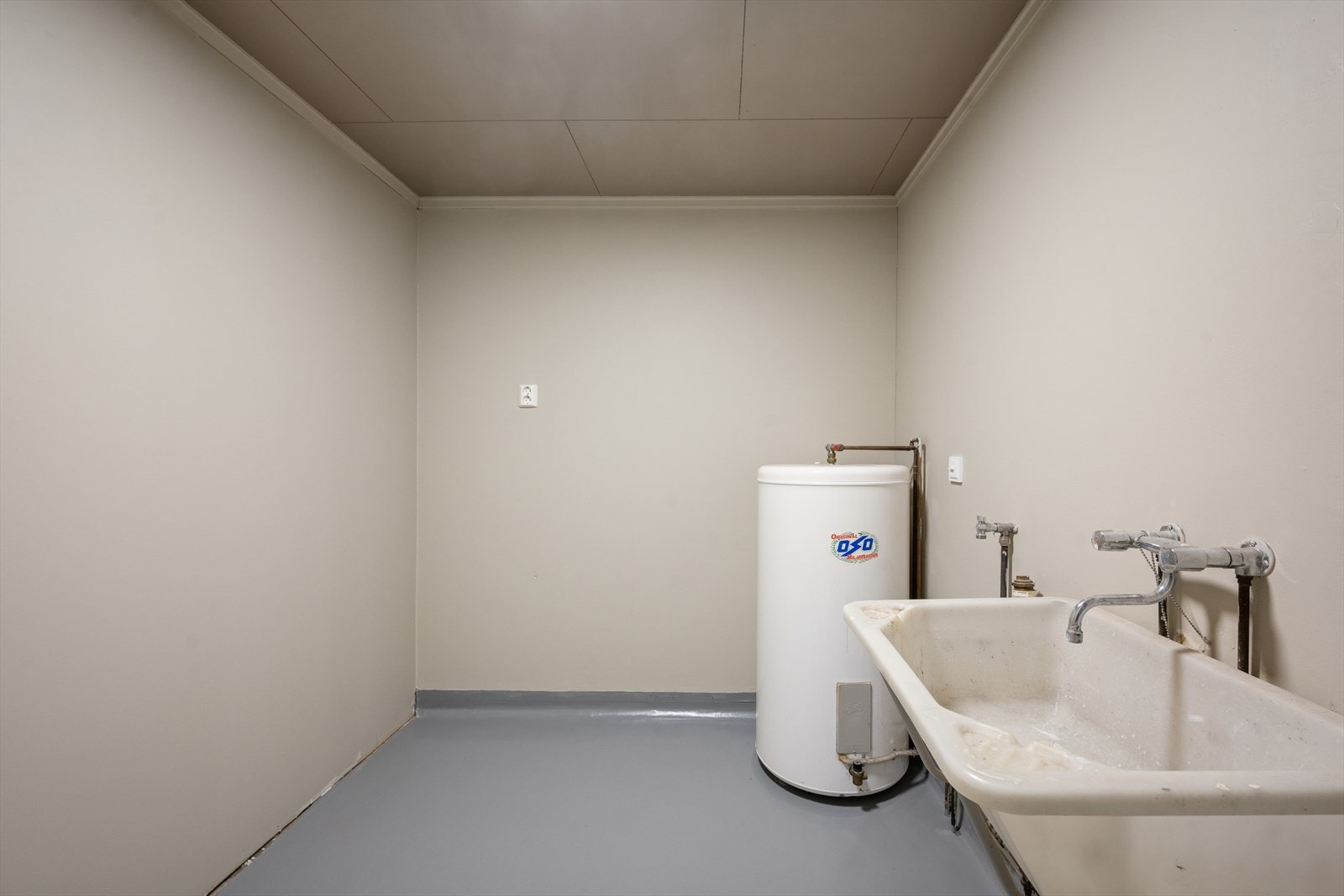 Boligen har et praktisk vaskerom utstyrt med en kum, et sluk i plast og boligens varmtvannsbereder. Galleribilde