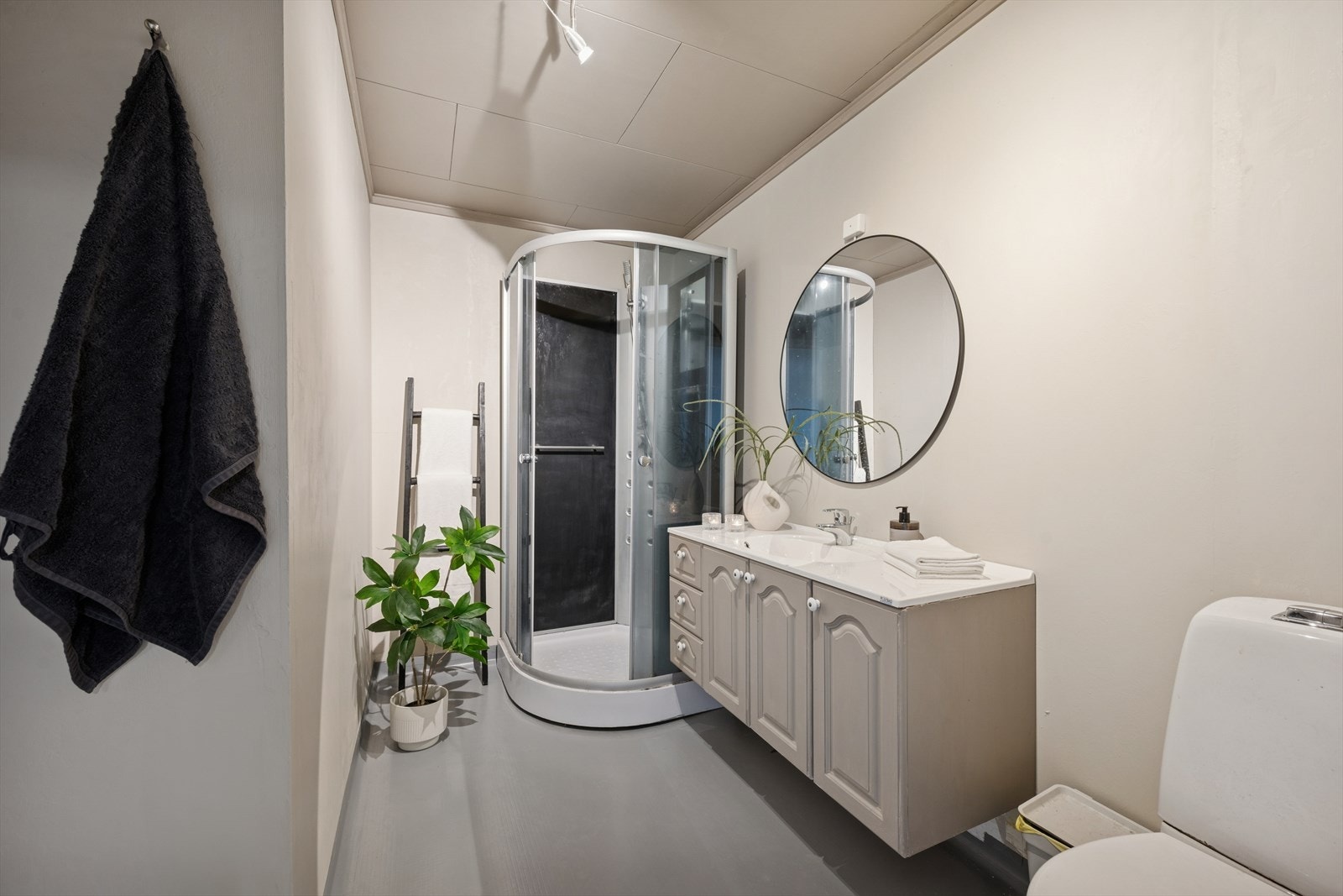 Badet er innredet med dusjkabinett, servant med tilhørende baderomsinnredning, speil og klosett. Det er elektrisk gulvvarme. Galleribilde